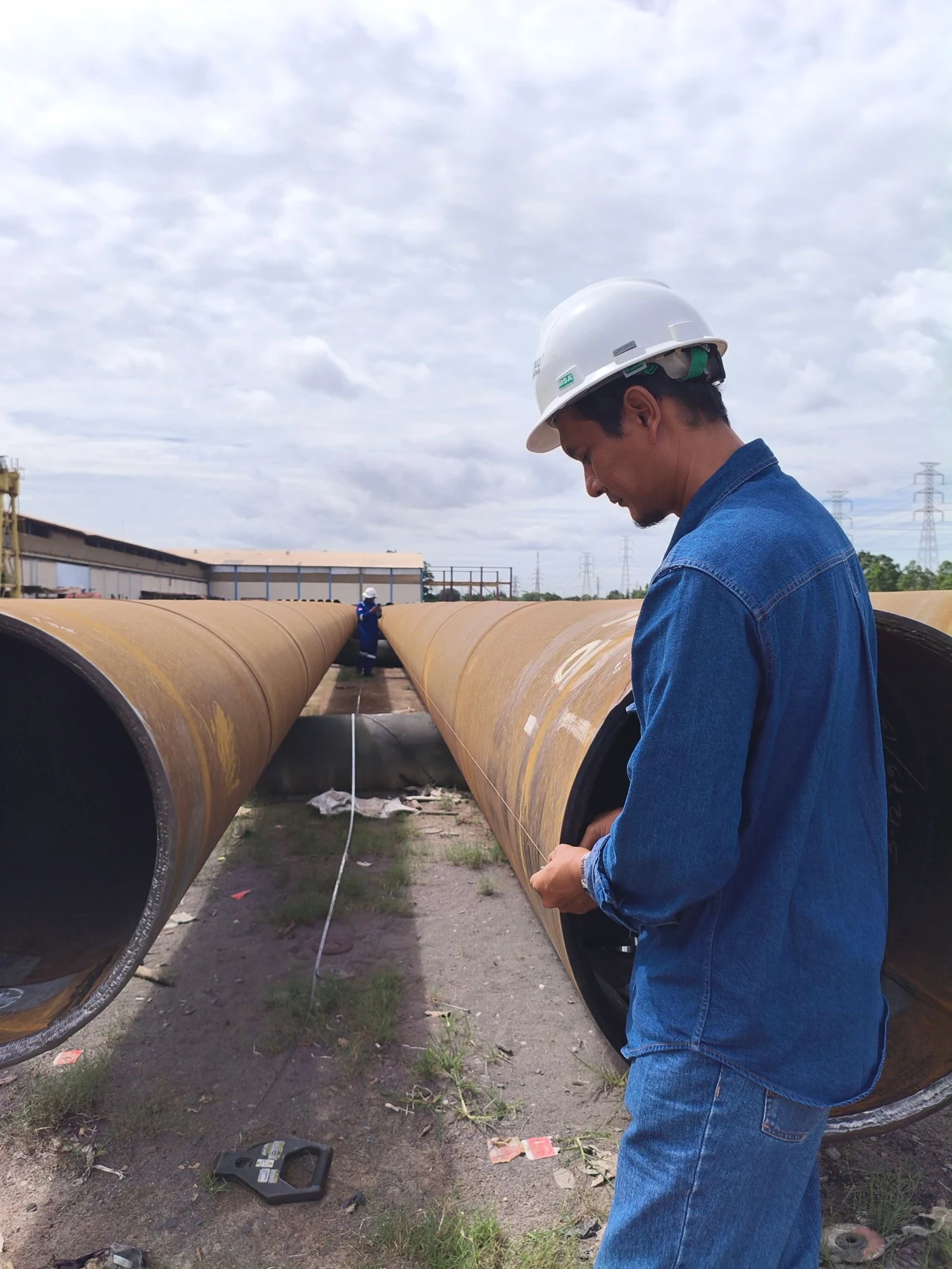 Personal técnico trabajando en la inspección y preparación de tuberías de gran diámetro